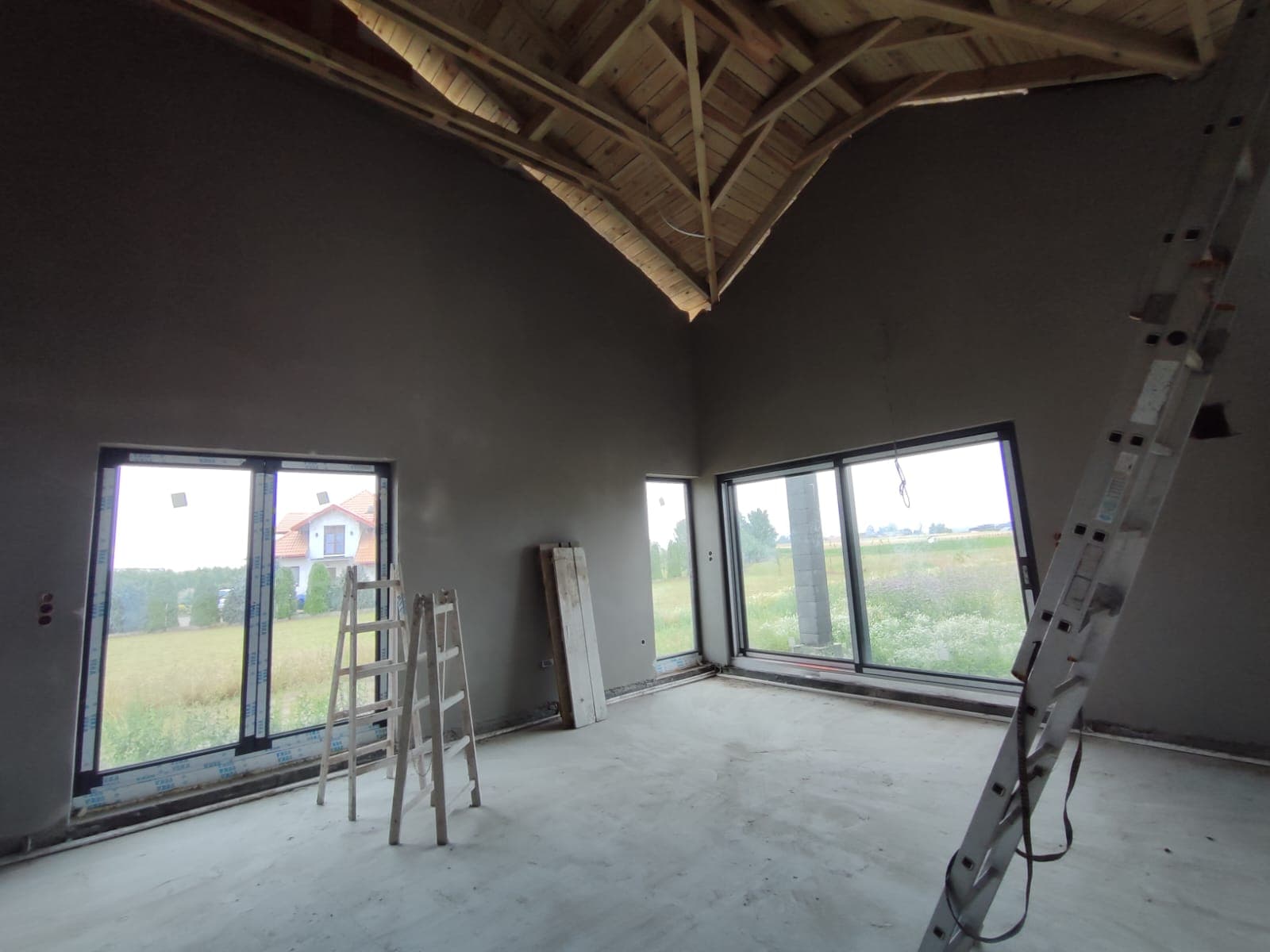 Tynki cementowe w salonie z dużymi oknami